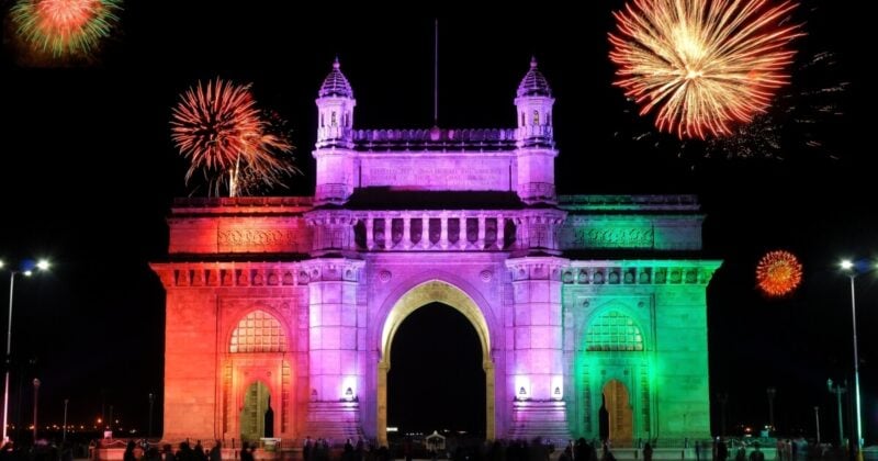 Mumbai Gateway of India at night with multicolored floodlights and fireworks