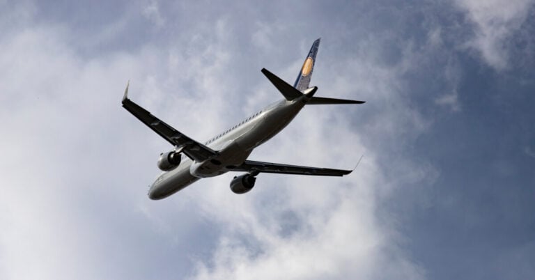 Jet flying in partially cloudy sky