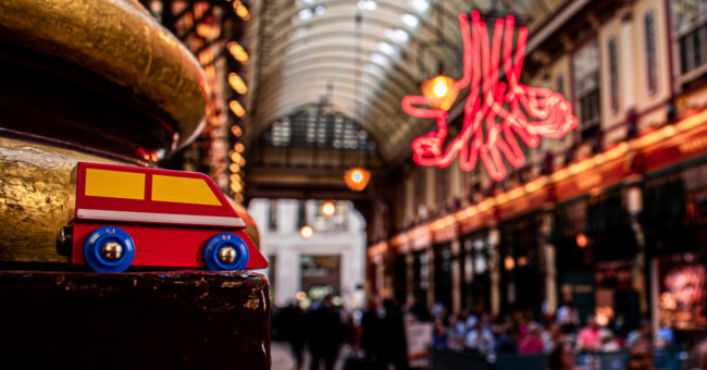 Interior of London's Leadenhall Market with small wooden toy double-decker bus in foreground